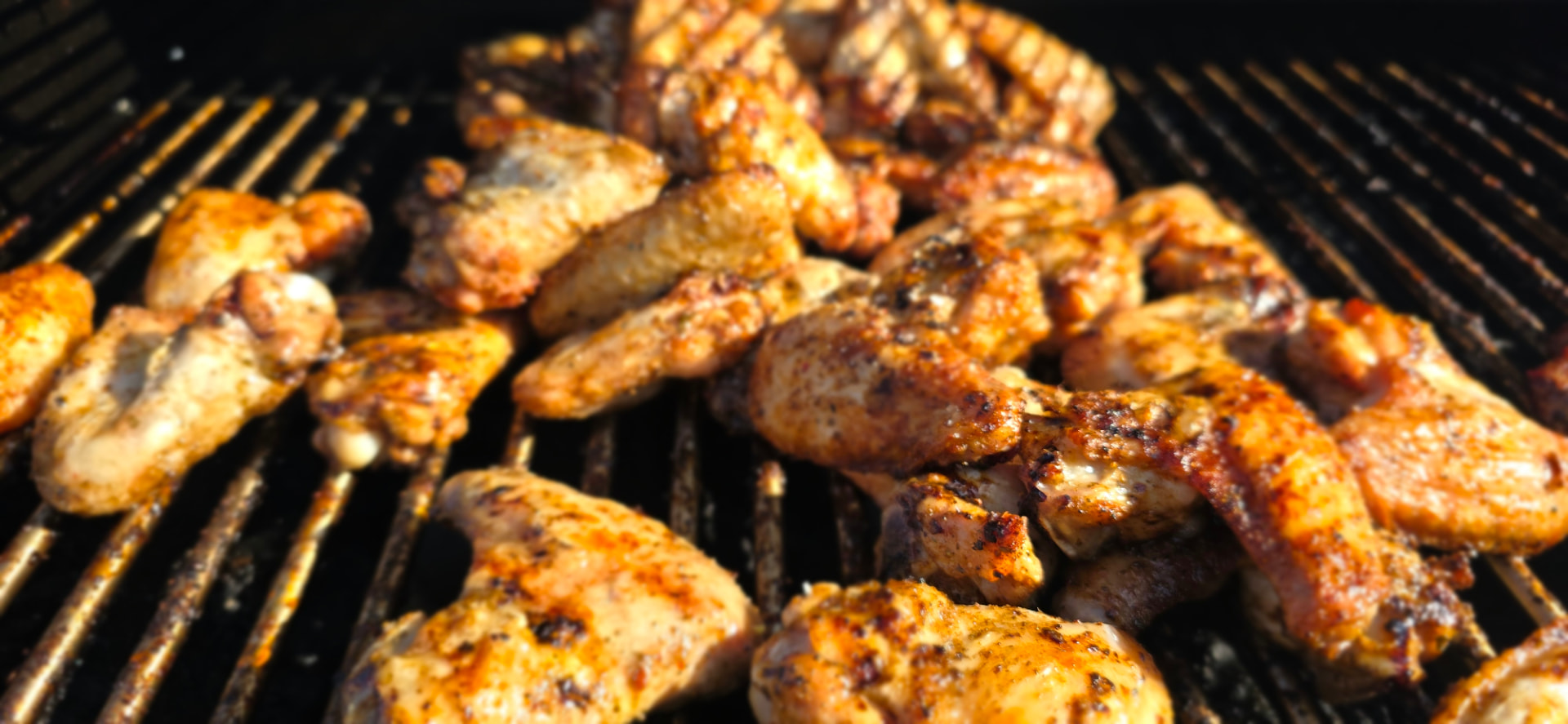 Peri-peri chicken wings crackling over open coals